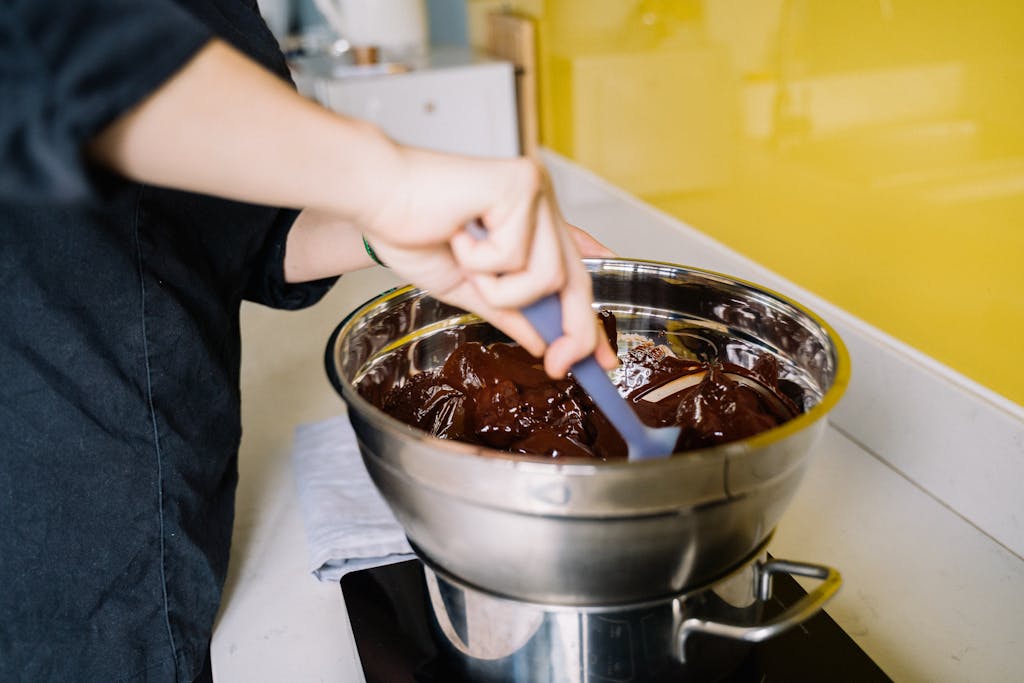 A Person Mixing Chocolate on a Stainless Bowl